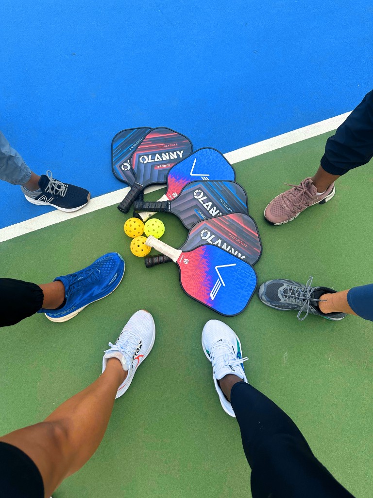 Players gathering in a circle around paddles and balls