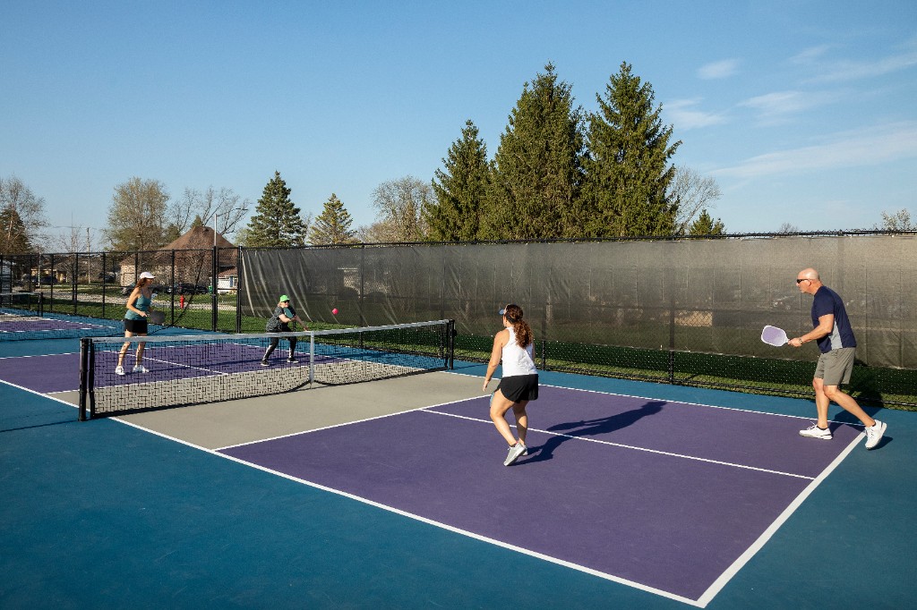 Four friends playing doubles pickleball together